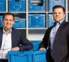 Geschäftsführer Dominik Lemken und Thomas Heilen vor blauen Kunststoff Faltboxen