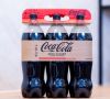 Multipack mit sechs 1,5-l-PET-Coca-Cola-Flaschen, die von der Papierbanderole Hug-IT fixiert werden.