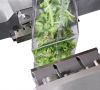 Verpackung mit frischem Salat in der Siegelmaschine
