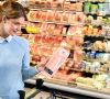 Frau mit Verpackung in der Hand im Supermarkt